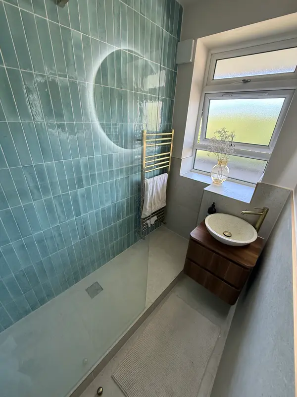 Bathroom renovation with green tiles, walk-in shower and wall-hung vanity