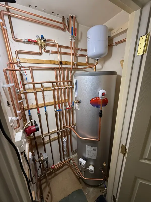 Hot water cylinder installation with neat copper pipework