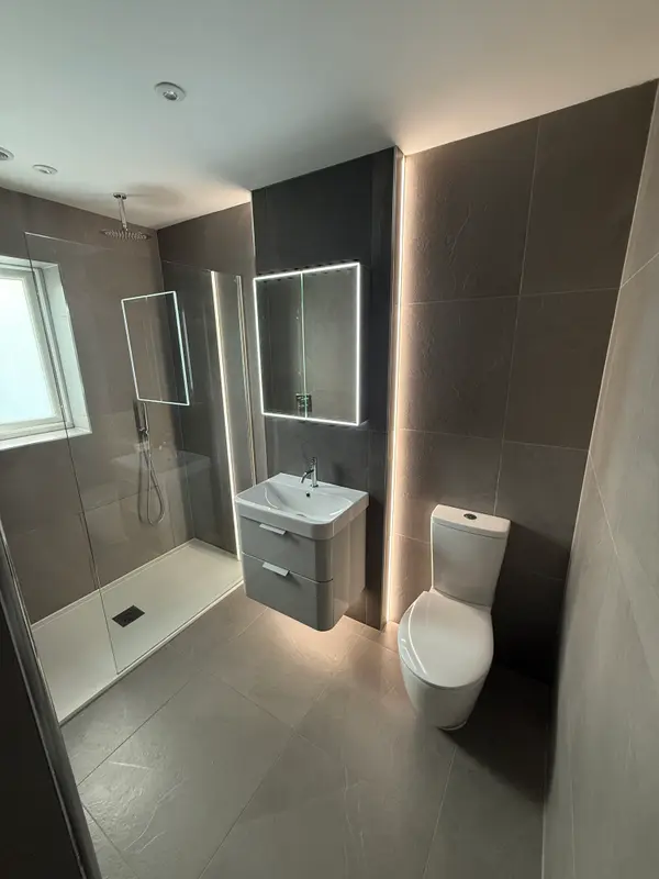 Modern grey shower room with walk-in shower, vanity unit and illuminated mirror
